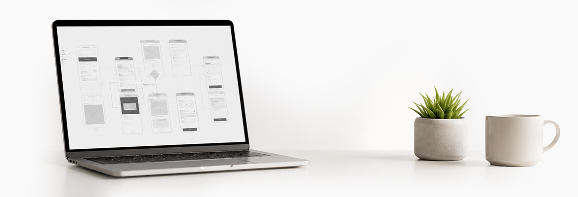  UX workspace with laptop showing wireframes